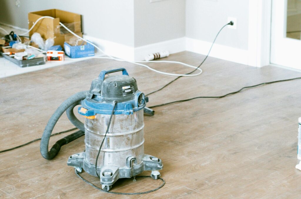Vacuum and tools in a room undergoing renovation, showcasing home improvement.